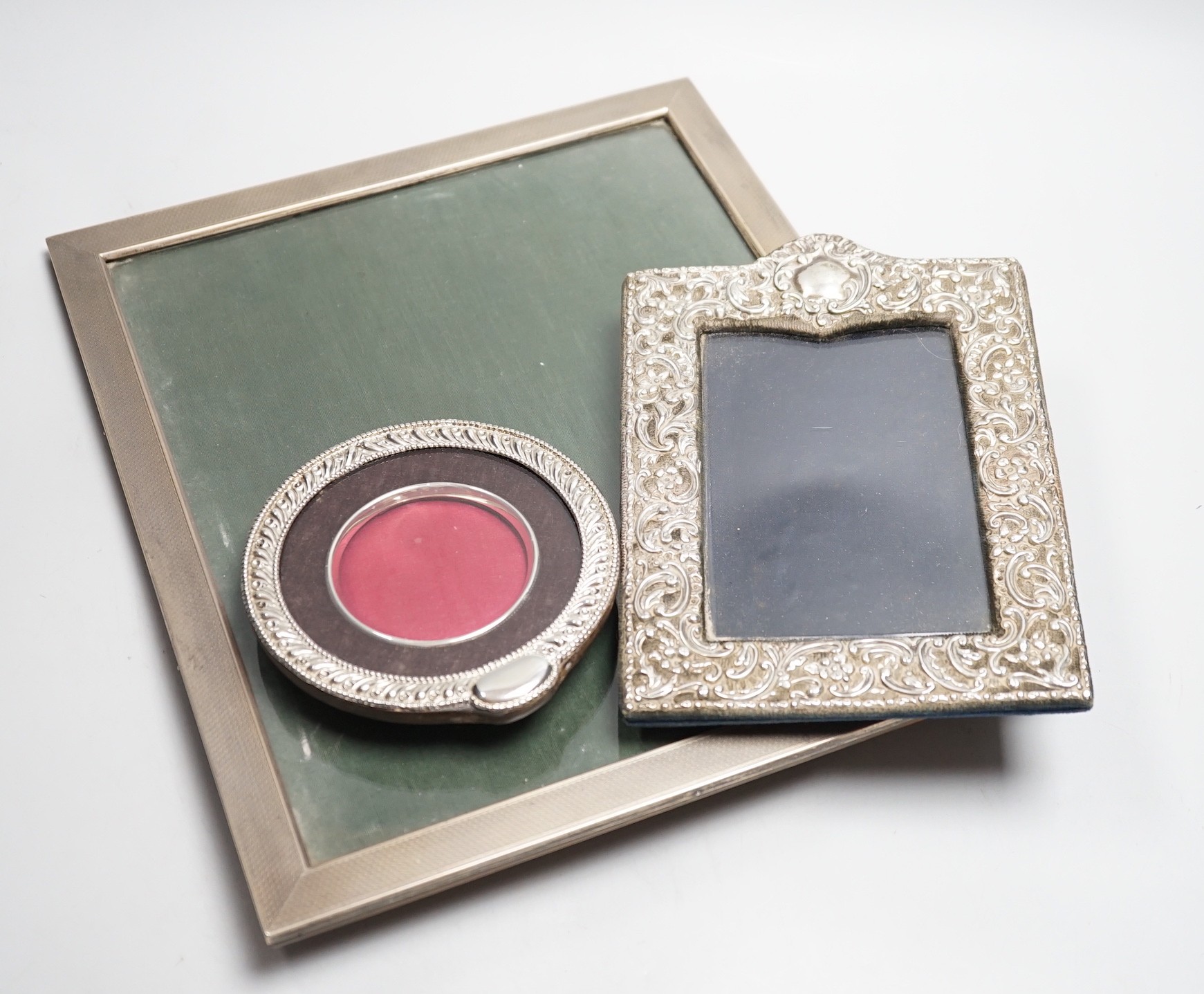 A large 1920's engine turned silver mounted rectangular photograph frame, Birmingham, 1928, 33.2cm and two other silver mounted photograph frames including circular.
